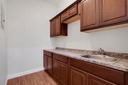 Kitchenette with plenty of cabinets, granite countertops, and a sink.